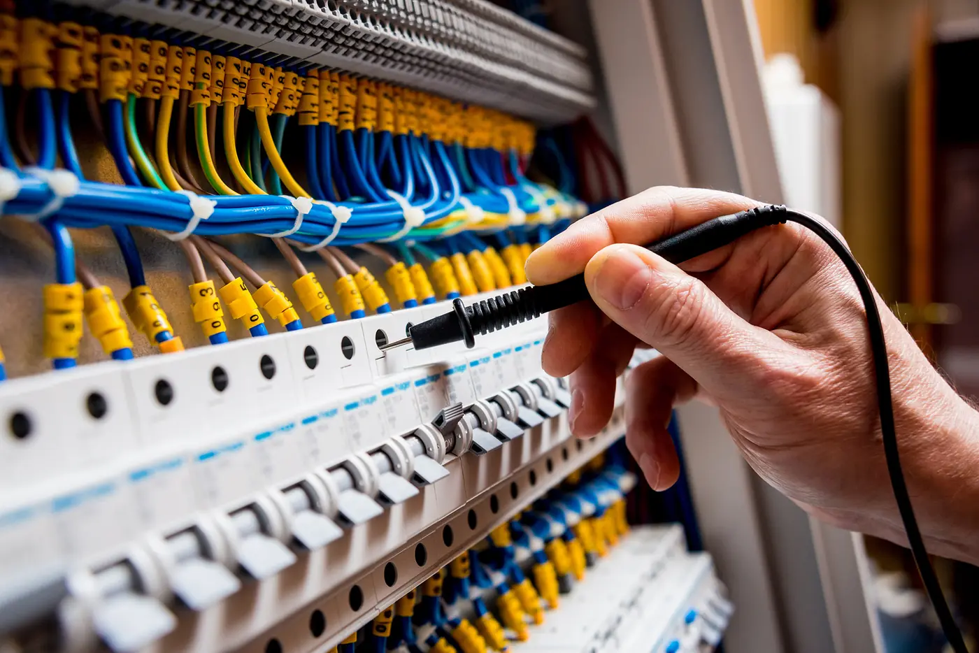 Electrician testing circuit breakers before giving an electrical quote in Swansea